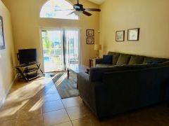 Two large settees and a TV, with access to the pool area.